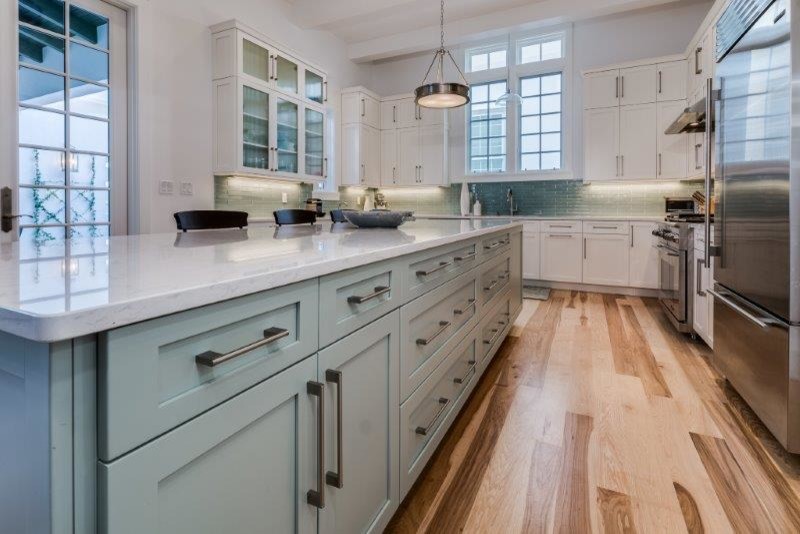 Example of a large transitional u-shaped light wood floor open concept kitchen design in Miami with blue cabinets, quartzite countertops, blue backsplash and an island