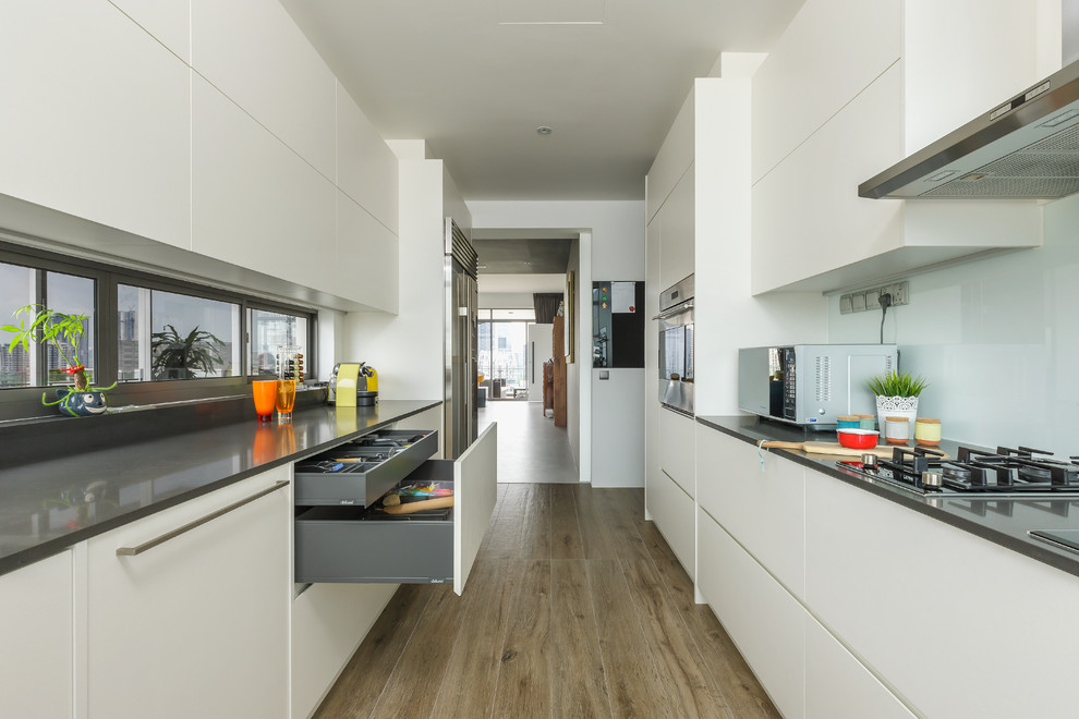 Design ideas for a contemporary galley eat-in kitchen in Singapore with an undermount sink, flat-panel cabinets, white cabinets and no island.