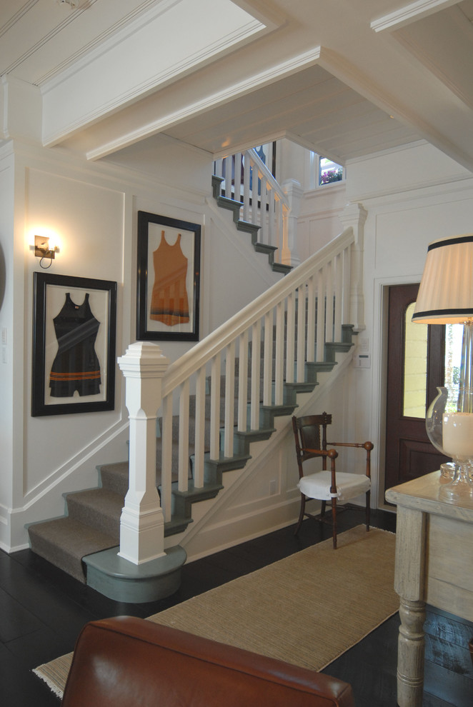 This is an example of a beach style entryway in Miami with white walls and dark hardwood floors.