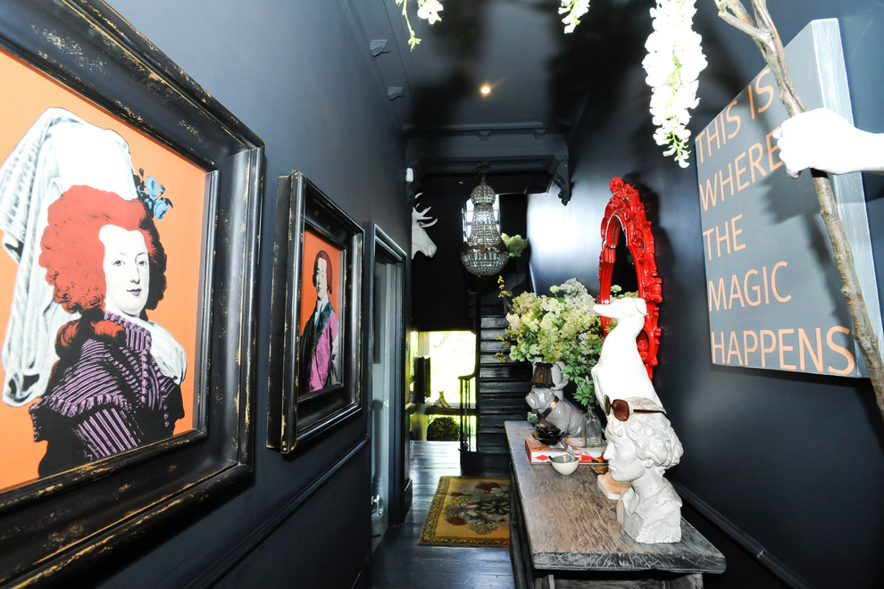 Eclectic hallway in London with black floor.