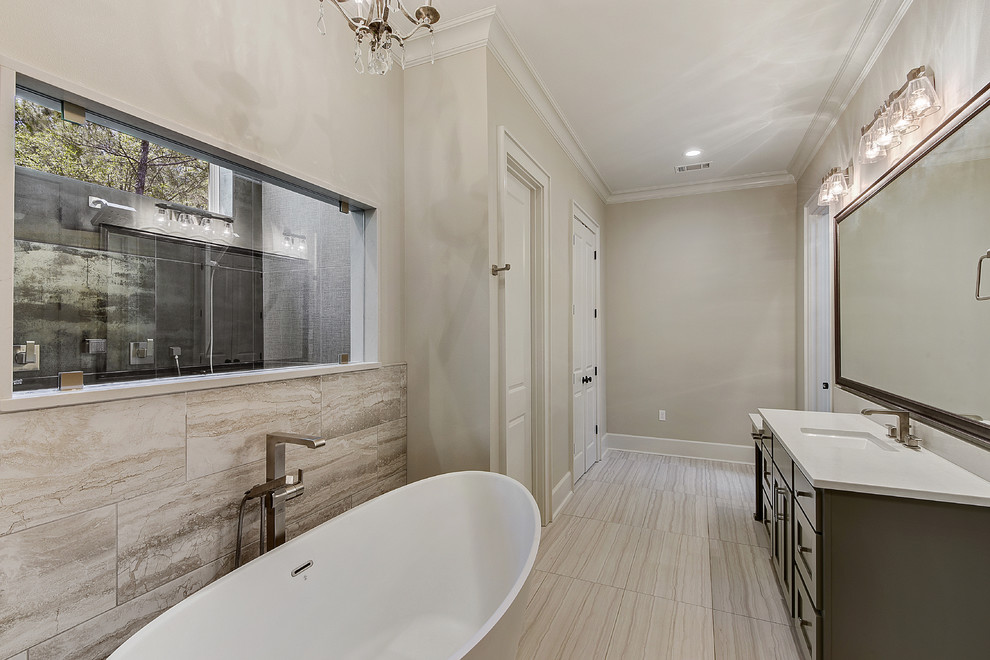 Photo of a large transitional master bathroom in New Orleans with a freestanding tub, shaker cabinets, black cabinets, an alcove shower, black tile, metal tile, beige walls, porcelain floors, an undermount sink, engineered quartz benchtops, beige floor and white benchtops.
