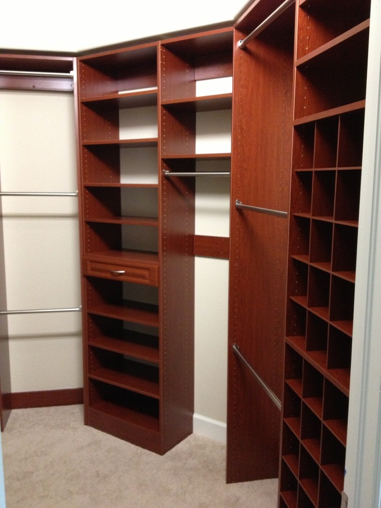 Mid-sized traditional gender-neutral walk-in wardrobe in Miami with open cabinets, carpet and dark wood cabinets.