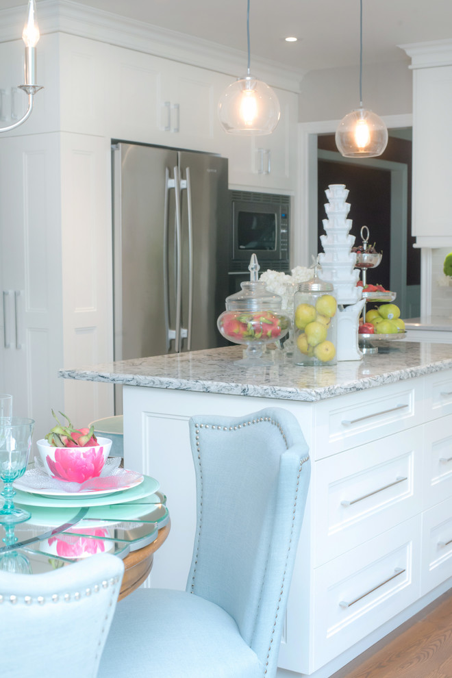 Example of a mid-sized transitional u-shaped eat-in kitchen design in Toronto with shaker cabinets, white cabinets, white backsplash, an island, quartz countertops and stainless steel appliances