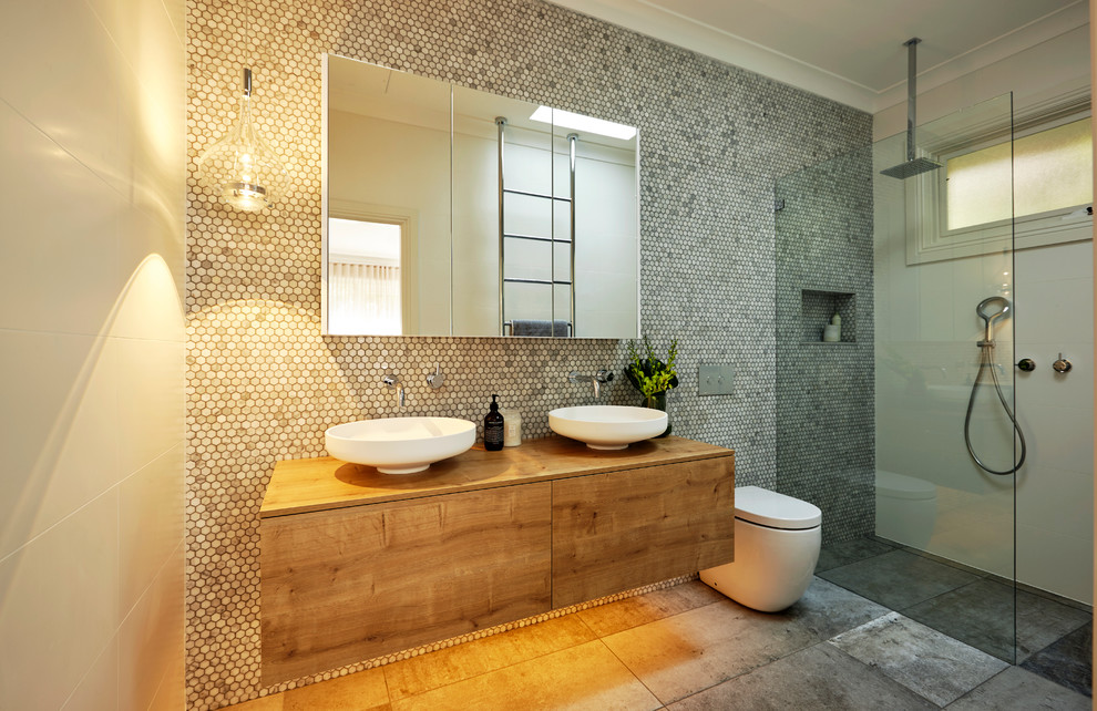 Mid-sized contemporary master bathroom in Sydney with medium wood cabinets, a one-piece toilet, gray tile, mosaic tile, white walls, ceramic floors, a vessel sink, wood benchtops, flat-panel cabinets, an alcove shower, an open shower and brown benchtops.