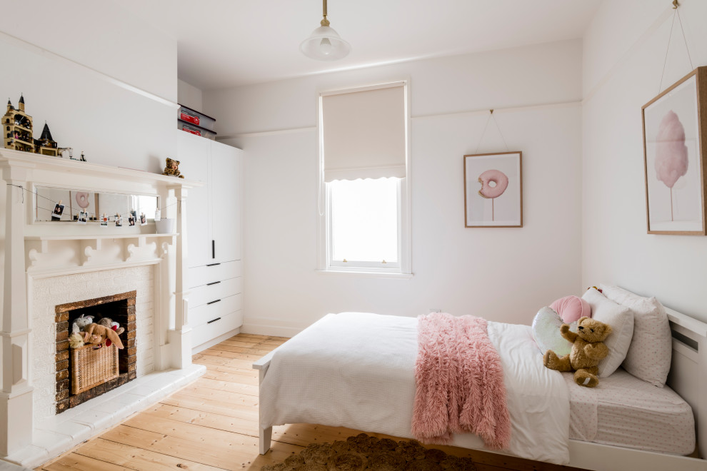 Foto på ett mellanstort funkis flickrum kombinerat med sovrum och för 4-10-åringar, med vita väggar, mellanmörkt trägolv och beiget golv