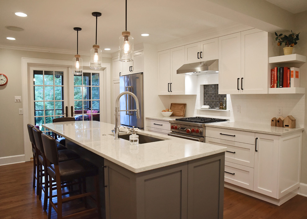 Enclosed kitchen - mid-sized transitional medium tone wood floor and brown floor enclosed kitchen idea with an undermount sink, flat-panel cabinets, white cabinets, quartz countertops, white backsplash, ceramic backsplash, stainless steel appliances, an island and gray countertops