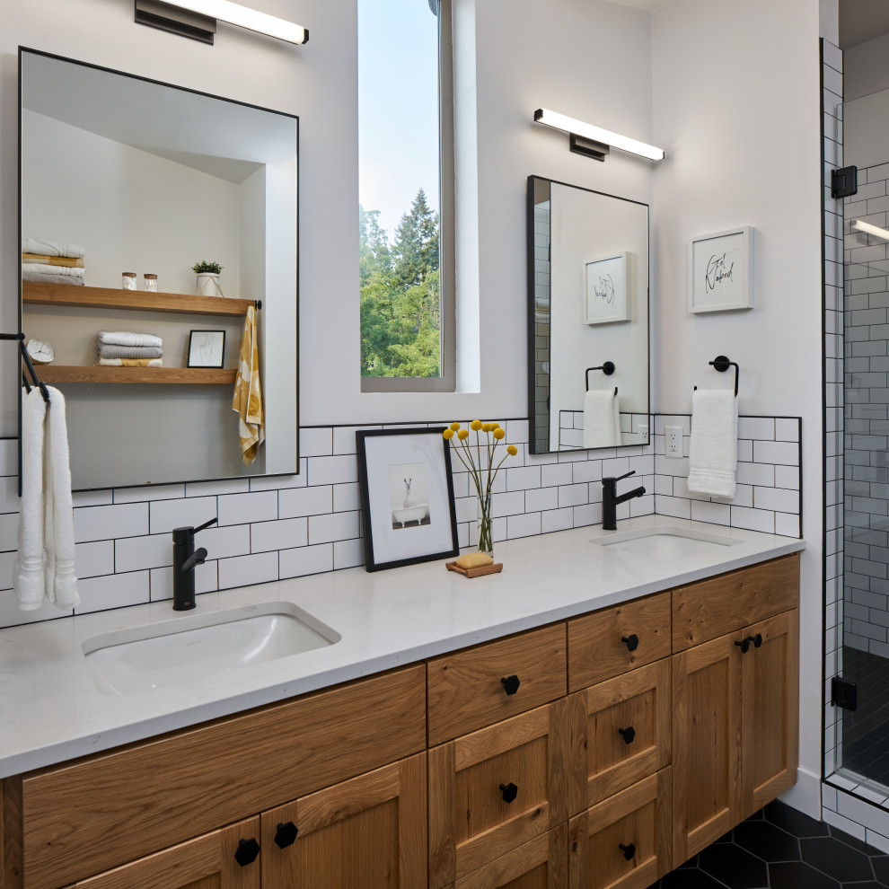 Photo of a mid-sized modern master bathroom in Other with shaker cabinets, medium wood cabinets, an alcove shower, a one-piece toilet, white tile, ceramic tile, white walls, ceramic floors, an undermount sink, engineered quartz benchtops, black floor, a hinged shower door, white benchtops, a double vanity, a built-in vanity and vaulted.