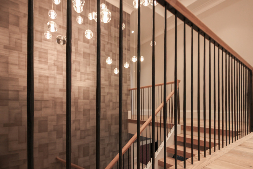 Design ideas for a large modern wood u-shaped staircase in DC Metro with wood risers, metal railing and wallpaper.