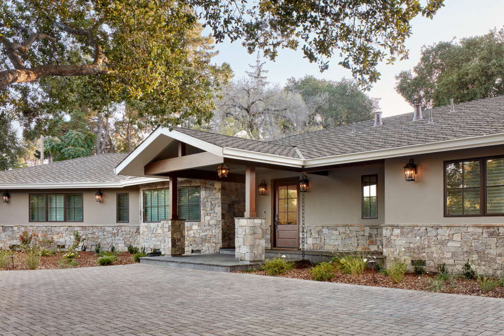 This is an example of a large arts and crafts one-storey stucco beige house exterior in San Francisco with a hip roof, a mixed roof and a brown roof.