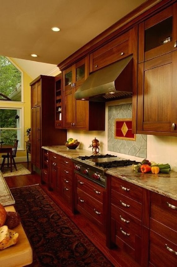 Photo of a galley eat-in kitchen in Atlanta with recessed-panel cabinets, dark wood cabinets, granite benchtops, stainless steel appliances, medium hardwood floors and with island.