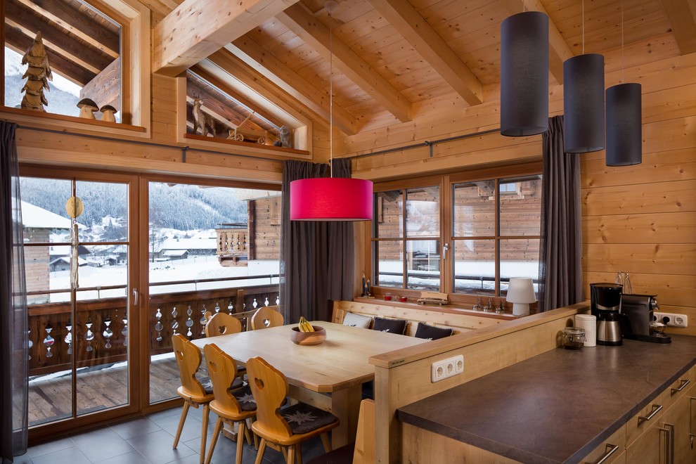 Photo of a large rustic kitchen/dining room with brown walls and porcelain flooring.