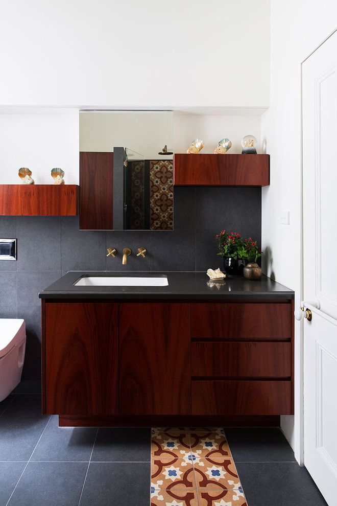 Small eclectic master bathroom in Melbourne with an undermount sink, flat-panel cabinets, medium wood cabinets, an open shower, a wall-mount toilet, multi-coloured tile, ceramic tile, white walls, slate floors and engineered quartz benchtops.