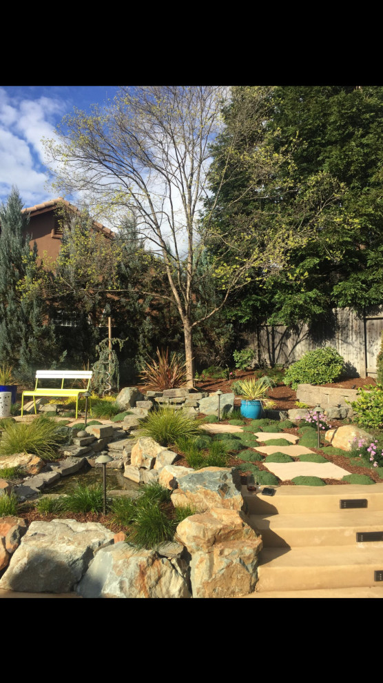 Стильный дизайн: солнечный, летний засухоустойчивый сад на заднем дворе в средиземноморском стиле с камнем в ландшафтном дизайне, хорошей освещенностью и покрытием из каменной брусчатки - последний тренд