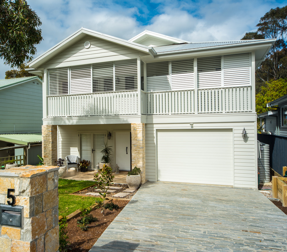 Photo of a mid-sized beach style two-storey grey house exterior in Sydney with a metal roof.