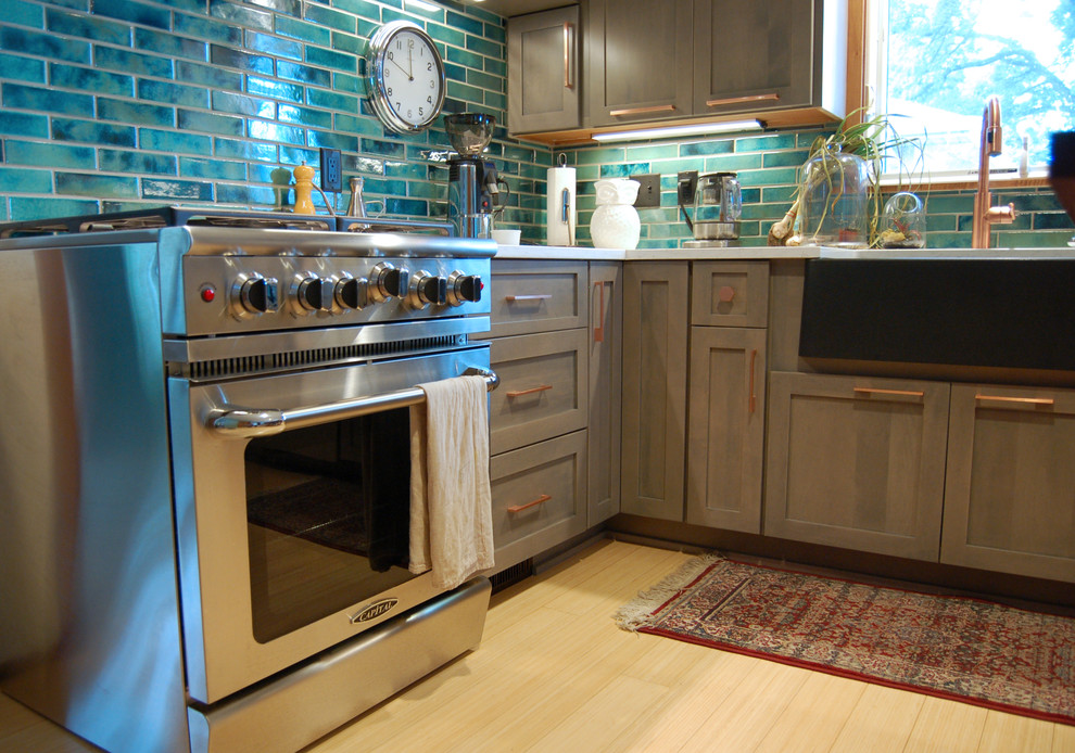 Inspiration for a transitional l-shaped light wood floor and multicolored floor open concept kitchen remodel with a farmhouse sink, shaker cabinets, gray cabinets, quartzite countertops, blue backsplash, ceramic backsplash, stainless steel appliances and an island