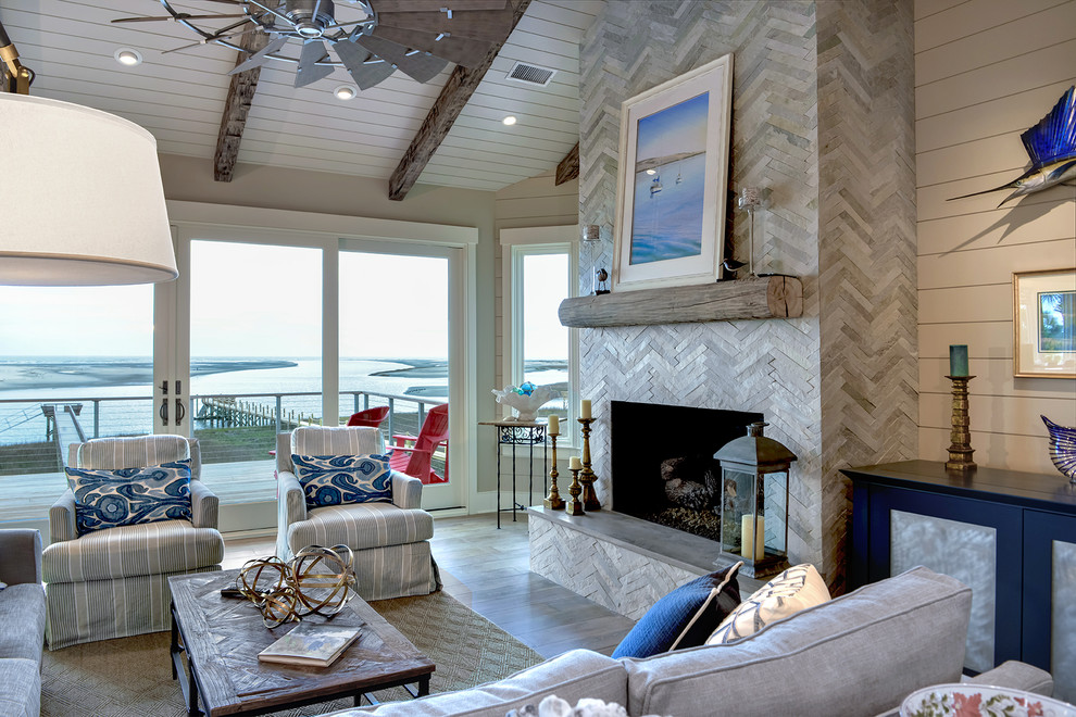 Design ideas for a beach style open concept living room in Charleston with a standard fireplace, a tile fireplace surround and a concealed tv.