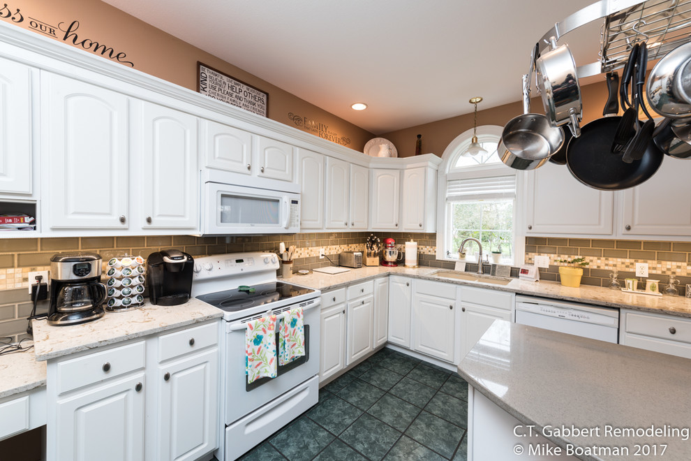 Inspiration for a mid-sized transitional l-shaped kitchen remodel in Chicago with a double-bowl sink, beaded inset cabinets, white cabinets, quartz countertops, beige backsplash, subway tile backsplash, stainless steel appliances and an island