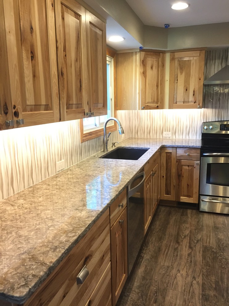 Mid-sized mountain style u-shaped laminate floor and brown floor eat-in kitchen photo in Omaha with an undermount sink, raised-panel cabinets, light wood cabinets, quartz countertops, beige backsplash, porcelain backsplash, stainless steel appliances, an island and gray countertops