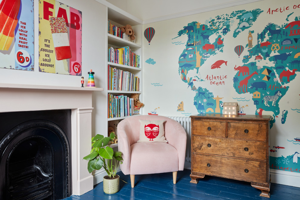 Medium sized classic children’s room for girls in London with pink walls, painted wood flooring, blue floors and wallpapered walls.