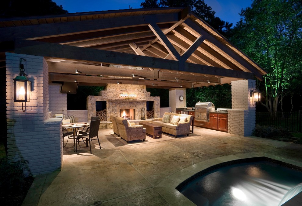 This is an example of a large contemporary backyard patio in Houston with a fire feature, concrete slab and a roof extension.