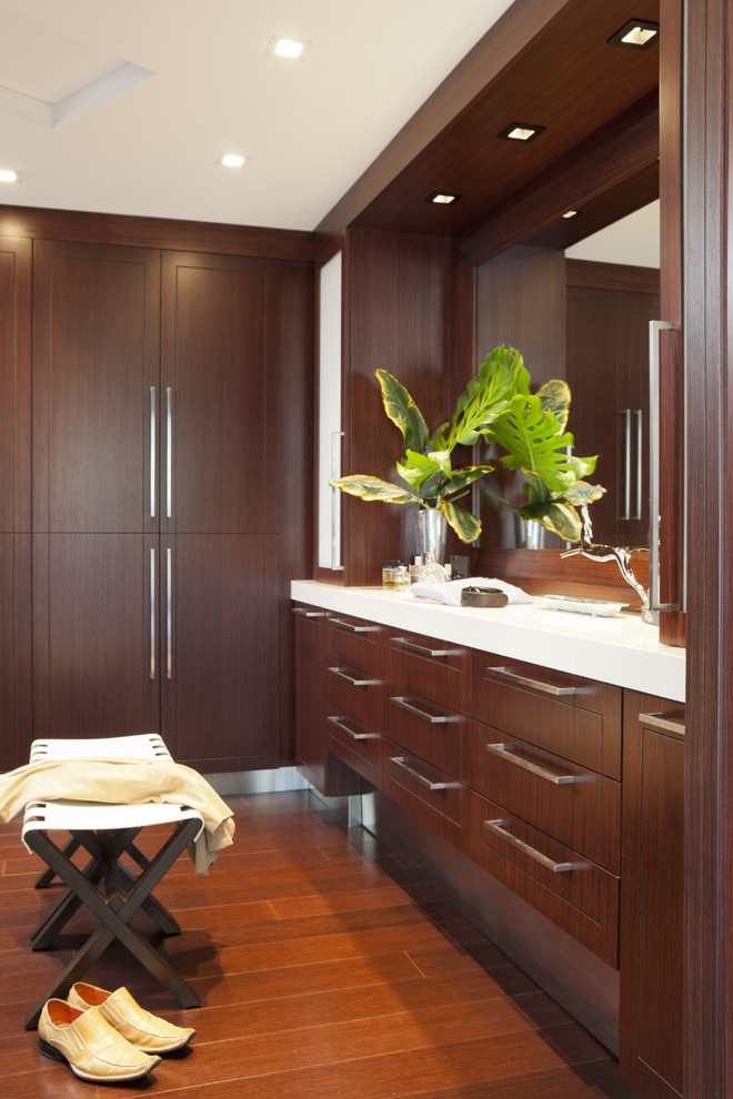 Design ideas for a contemporary dressing room in Other with dark wood cabinets.