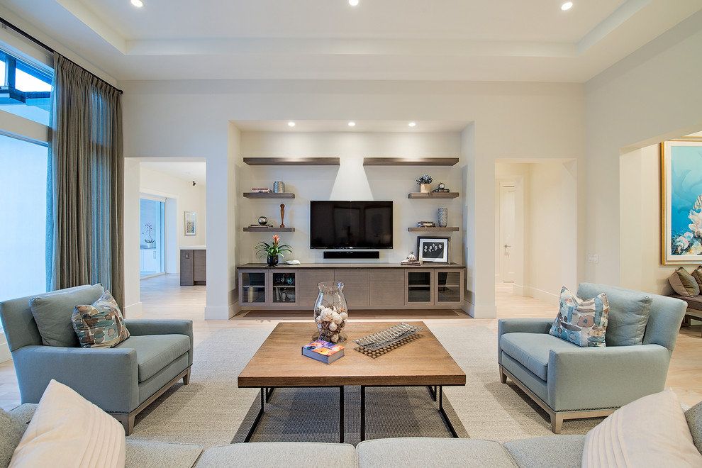 Beach style open concept family room in New York with white walls, light hardwood floors, a wall-mounted tv and beige floor.