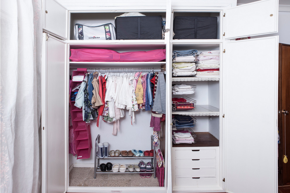 This is an example of a small transitional gender-neutral built-in wardrobe in Madrid with flat-panel cabinets and white cabinets.