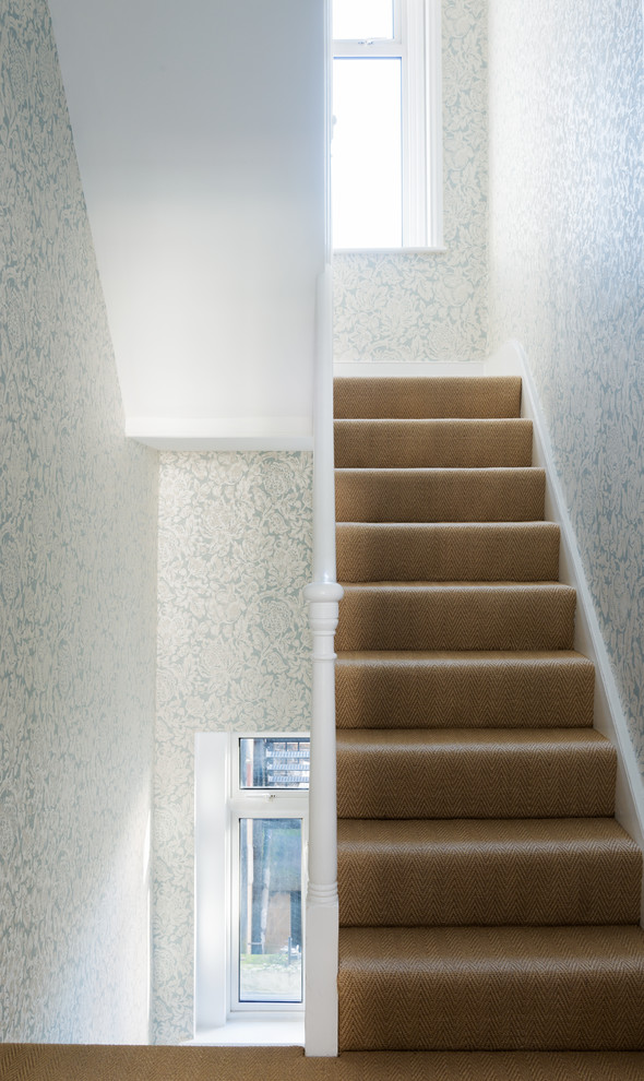 Design ideas for a mid-sized transitional carpeted straight staircase in London with carpet risers.
