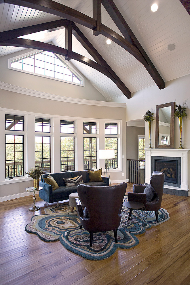 Large country formal open concept living room in Other with beige walls, medium hardwood floors, a standard fireplace, a plaster fireplace surround, no tv and brown floor.