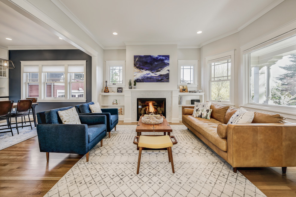 Large transitional formal open concept living room in Seattle with white walls, light hardwood floors, a standard fireplace, a tile fireplace surround, no tv and brown floor.