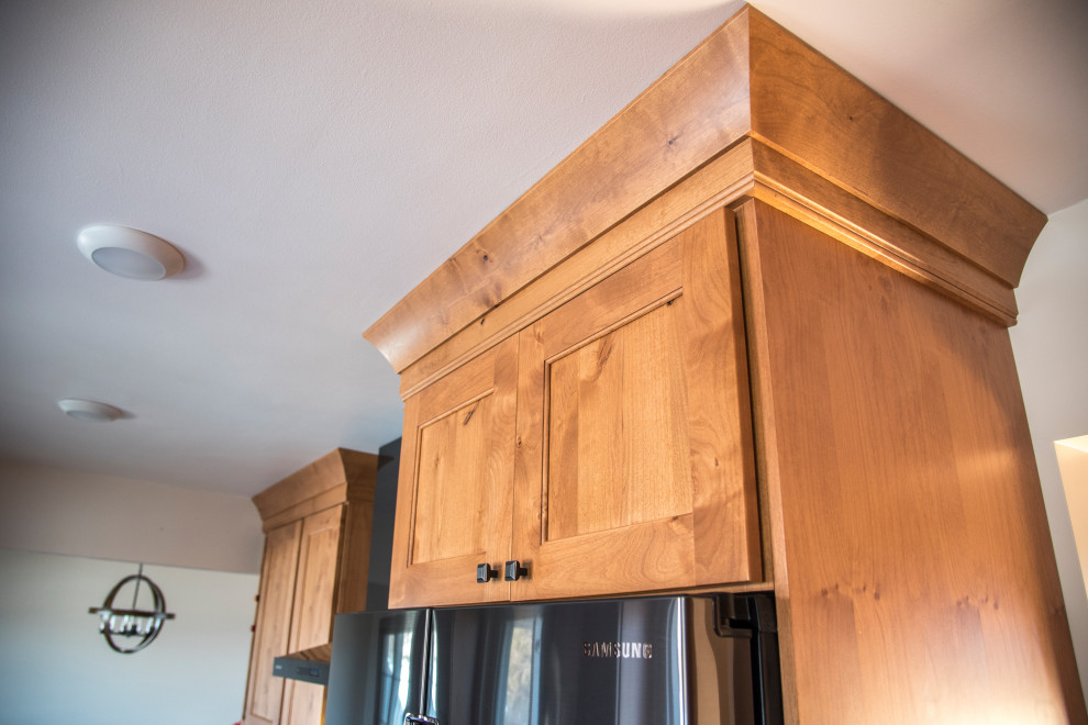 Eat-in kitchen - mid-sized rustic galley medium tone wood floor and brown floor eat-in kitchen idea in Denver with an undermount sink, shaker cabinets, medium tone wood cabinets, quartz countertops, gray backsplash, stone tile backsplash, black appliances, no island and brown countertops