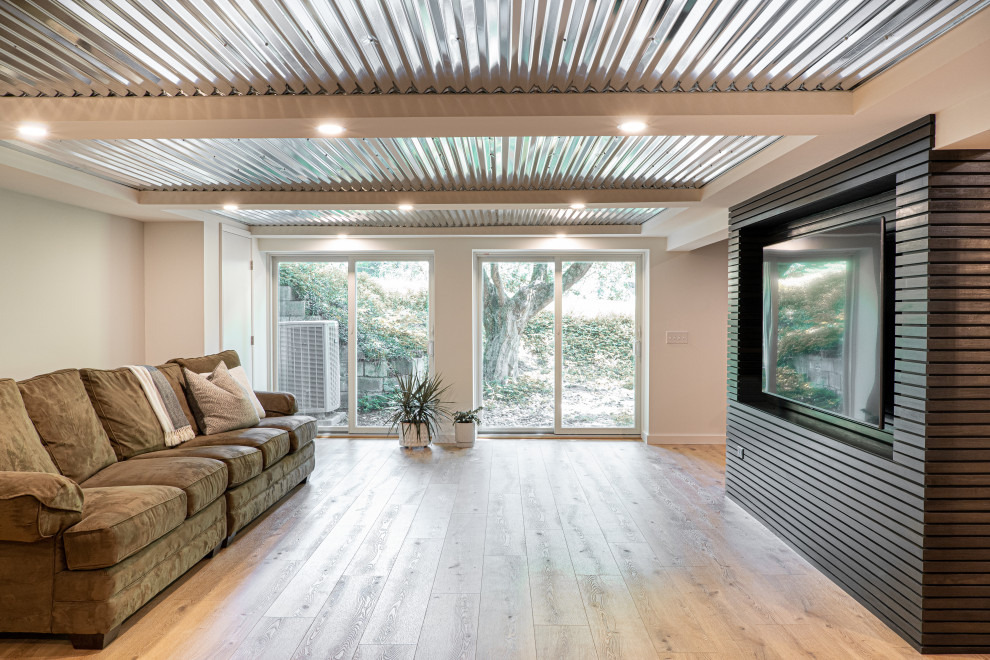 Photo of a medium sized midcentury walk-out basement in Baltimore with grey walls, vinyl flooring, a coffered ceiling and wood walls.