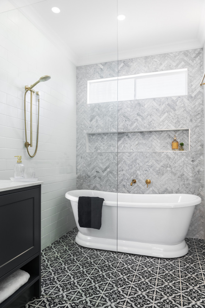 Photo of a large traditional master wet room bathroom in Brisbane with recessed-panel cabinets, black cabinets, a freestanding tub, gray tile, multi-coloured floor, an open shower, white benchtops, a niche and a built-in vanity.