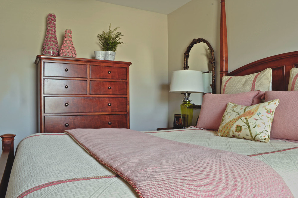 This is an example of a traditional guest bedroom in Louisville with beige walls and dark hardwood floors.