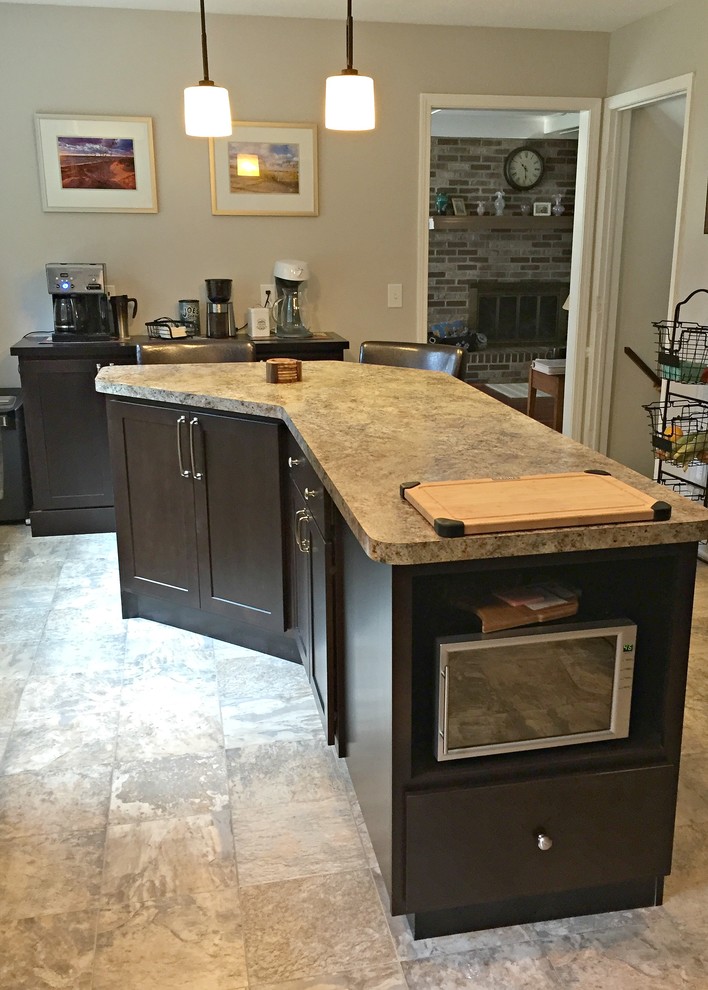 Open concept kitchen - mid-sized transitional l-shaped limestone floor open concept kitchen idea with a drop-in sink, shaker cabinets, dark wood cabinets, granite countertops, stainless steel appliances and an island