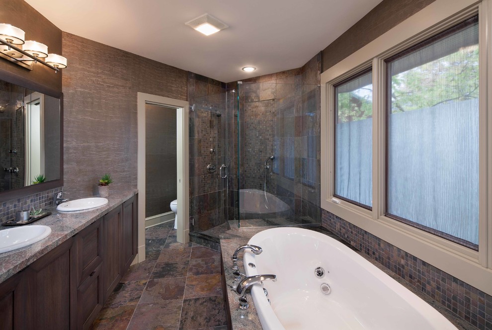 This is an example of a mid-sized transitional master bathroom in Chicago with shaker cabinets, dark wood cabinets, a drop-in tub, a corner shower, multi-coloured tile, mosaic tile, brown walls, slate floors, a drop-in sink and granite benchtops.