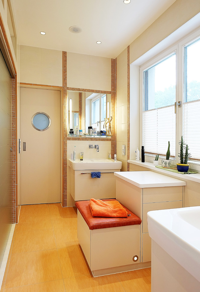 This is an example of a mid-sized contemporary bathroom in Berlin with louvered cabinets, brown cabinets, a drop-in tub, a curbless shower, a wall-mount toilet, beige tile, stone tile, white walls, ceramic floors, with a sauna, a vessel sink, beige floor and an open shower.