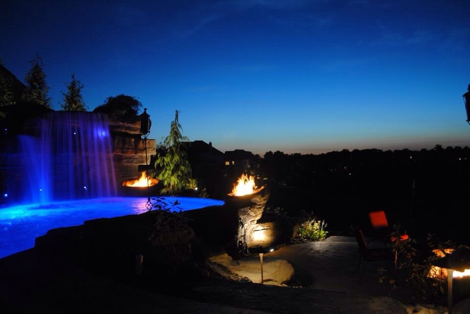 Large mountain style backyard stamped concrete and freeform natural pool fountain photo