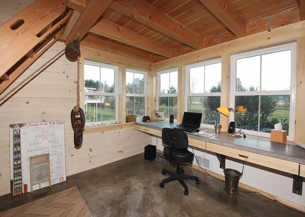 Inspiration for a mid-sized industrial home studio in Seattle with beige walls, concrete floors, no fireplace and a built-in desk.
