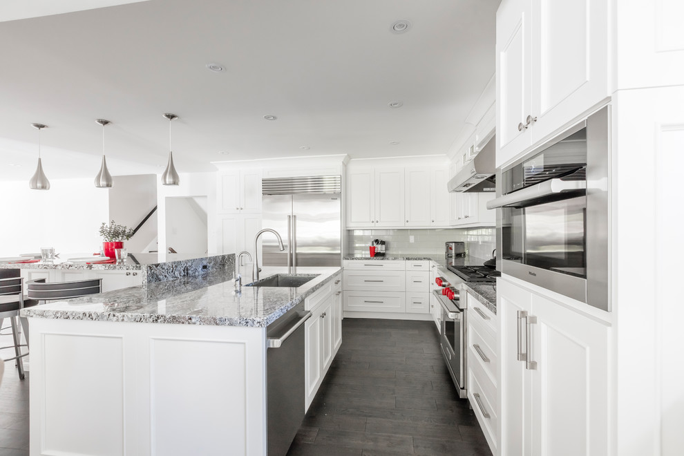 Kitchen - mid-sized transitional brown floor kitchen idea in Toronto with white cabinets, stainless steel appliances and an island