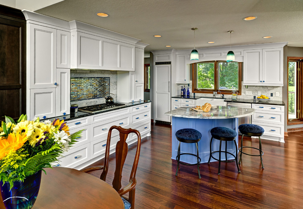 Large traditional l-shaped open plan kitchen in Minneapolis with recessed-panel cabinets, white cabinets, granite benchtops, white splashback, stone tile splashback, dark hardwood floors and with island.