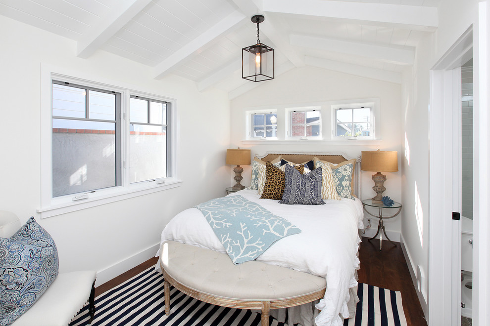 This is an example of a traditional bedroom in Orange County with white walls and dark hardwood floors.