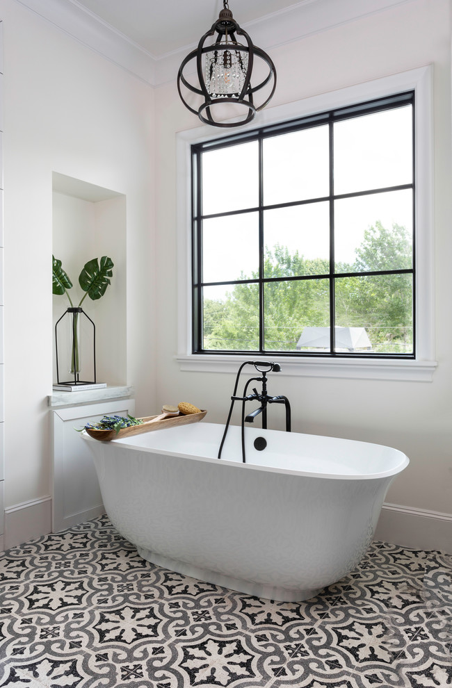 Inspiration for a transitional master bathroom in Houston with a freestanding tub, beige walls and multi-coloured floor.