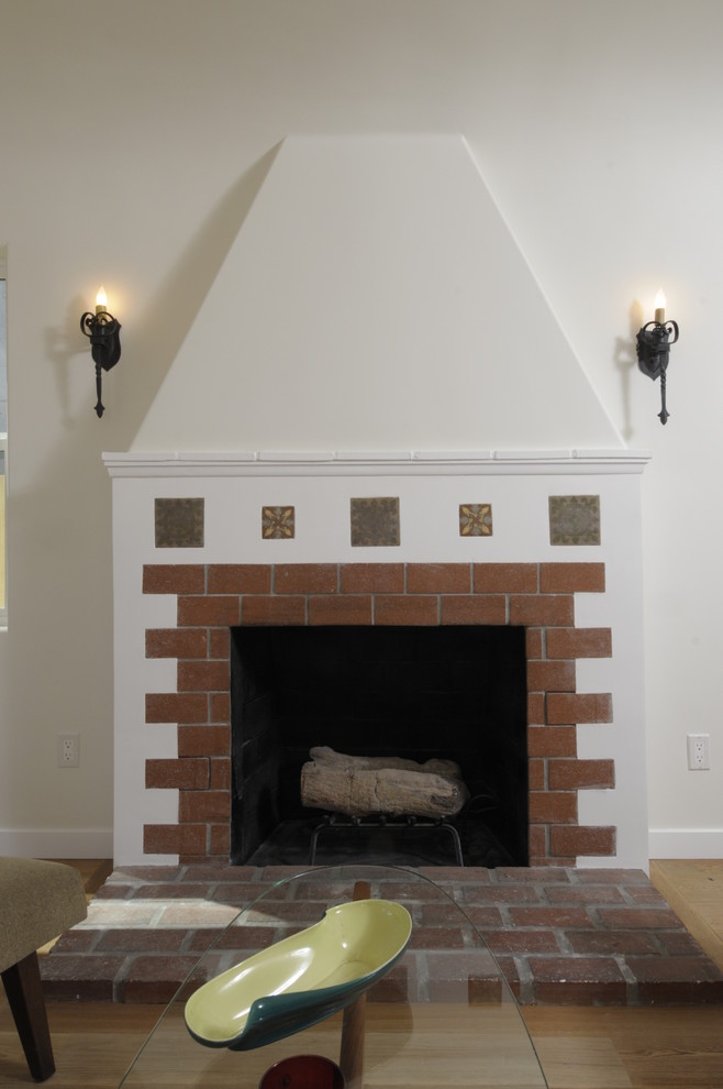 Photo of a mid-sized mediterranean formal open concept living room in Los Angeles with white walls, medium hardwood floors, a standard fireplace and a brick fireplace surround.