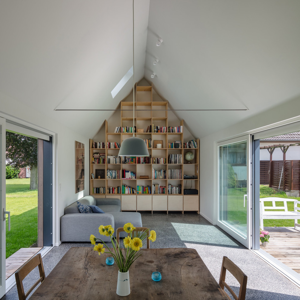 Mid-sized country open concept living room in Hamburg with a library, white walls, no fireplace, no tv, carpet and grey floor.