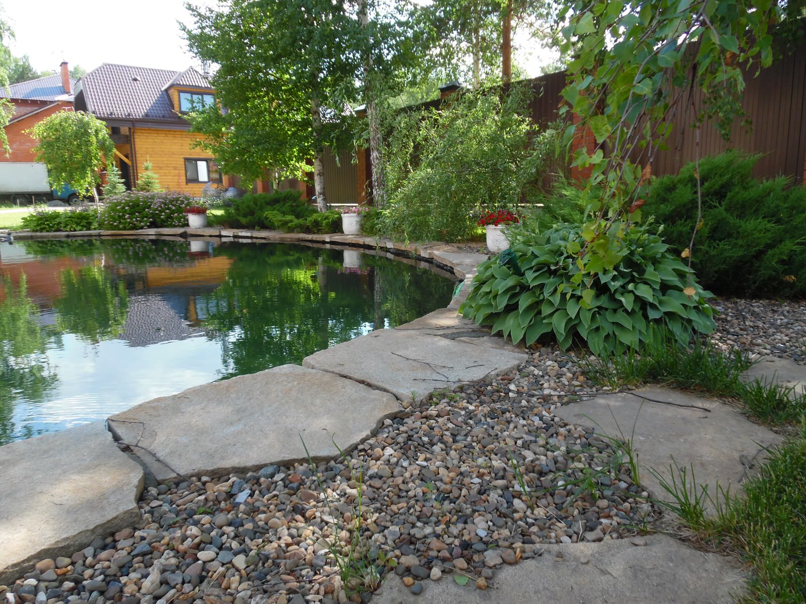 Современный сад с большим прудом.