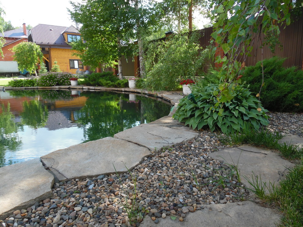 Современный сад с большим прудом.