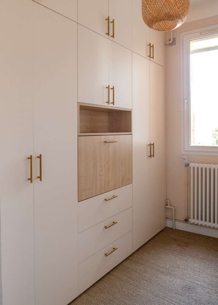 Modelo de despacho actual de tamaño medio sin chimenea con paredes beige, moqueta, escritorio empotrado y suelo beige