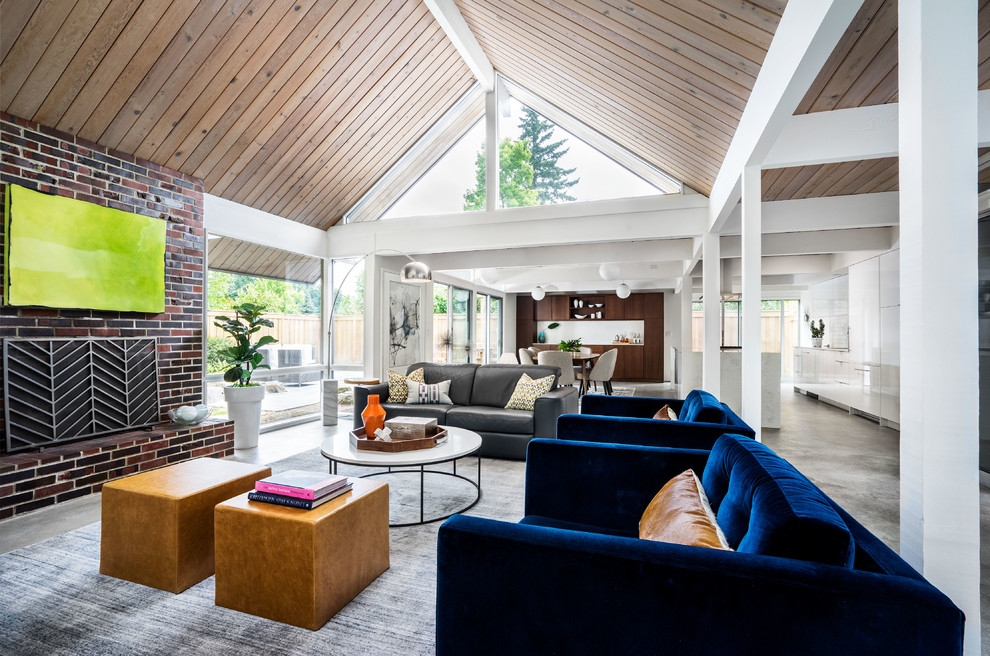 Small midcentury open concept living room in Portland with white walls, concrete floors, a standard fireplace, a brick fireplace surround and grey floor.