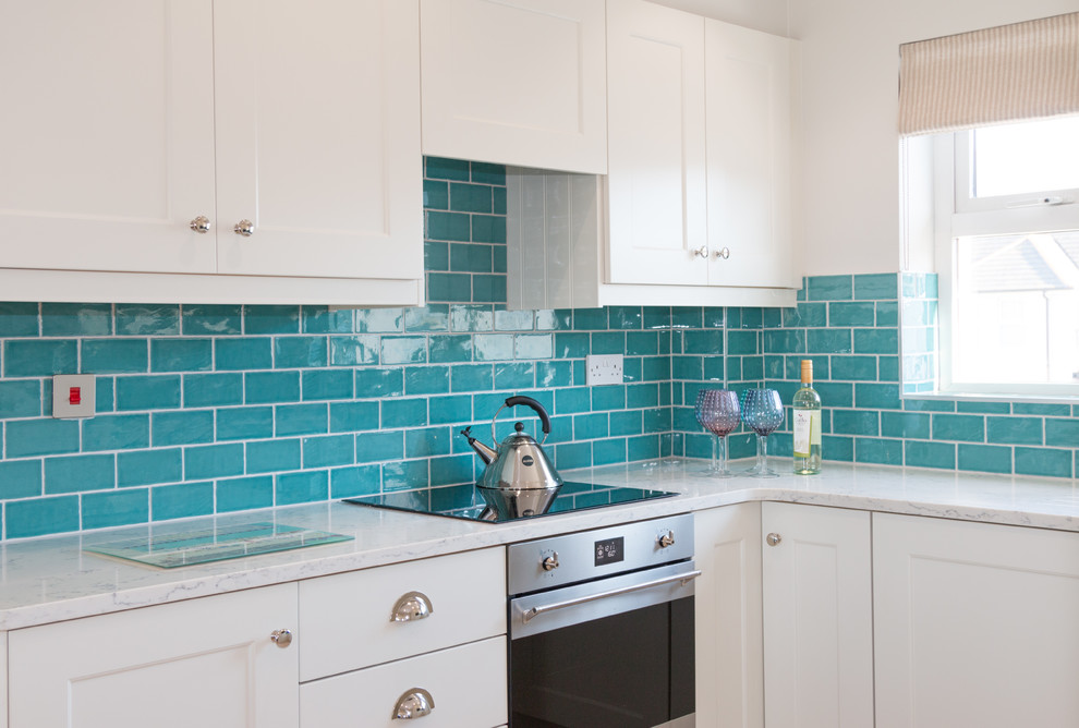 Inspiration for a small beach style u-shaped open plan kitchen in Other with an undermount sink, shaker cabinets, beige cabinets, marble benchtops, green splashback, ceramic splashback, stainless steel appliances, cement tiles and no island.